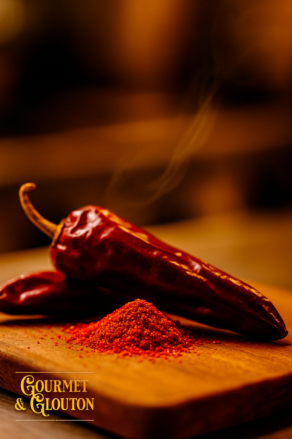 Gros plan sur du piment d’Espelette AOP en poudre et en gousses, mis en scène dans la cuisine du restaurant Gourmet & Glouton à Chaudesaigues