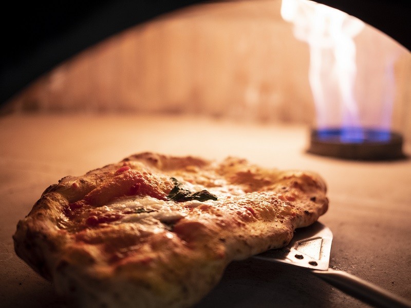 Pizza artisanale cuisant dans un four traditionnel à Chaudes-Aigues.