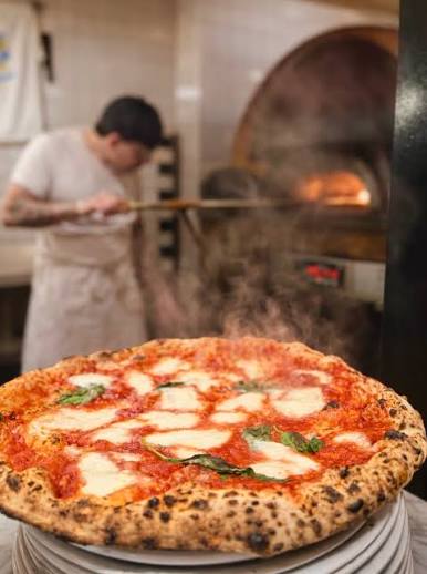Pizza artisanale cuisant dans un four traditionnel à Chaudes-Aigues.