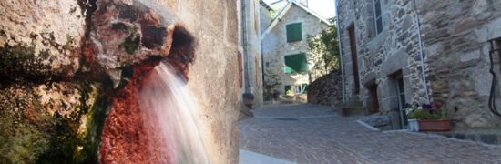 Source d’eau dans une rue de Chaudes-Aigues, symbole du village vivant hors saison et du temps long