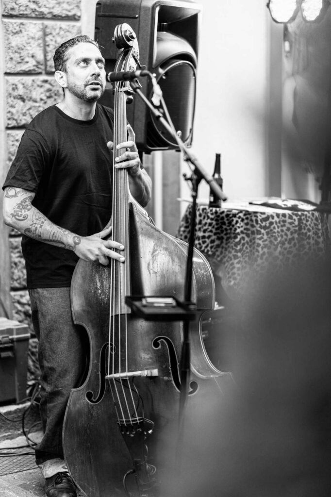Musicien jouant de la contrebasse lors d’un concert en terrasse chez Gourmet & Glouton à Chaudes-Aigues, dans une ambiance musicale authentique.