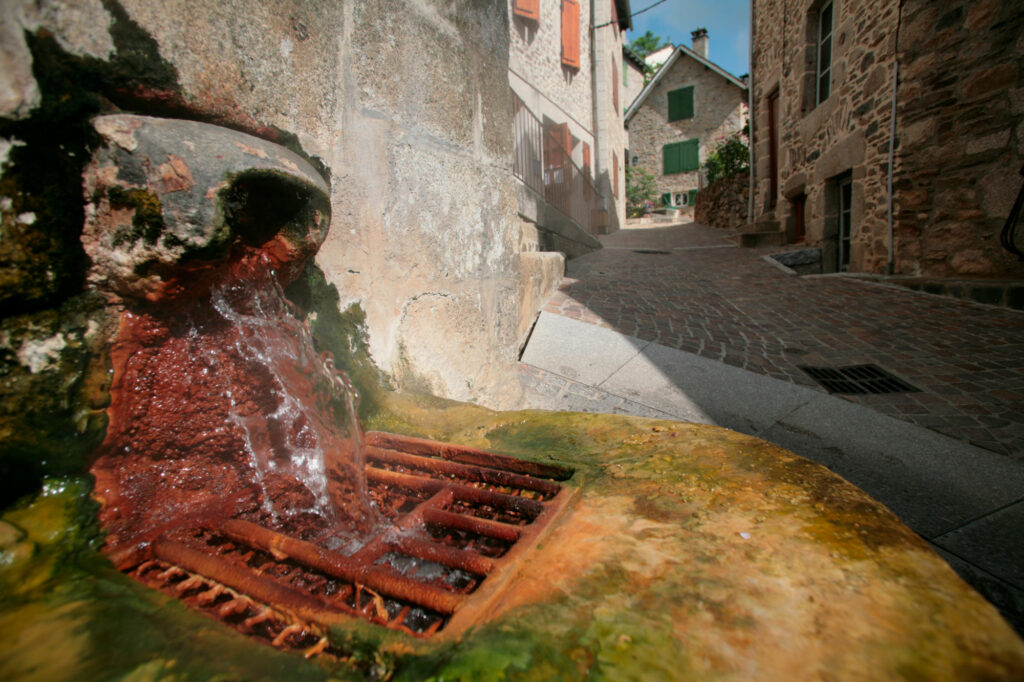 Source d’eau chaude à Chaudes-Aigues dans une rue du village thermal du Cantal