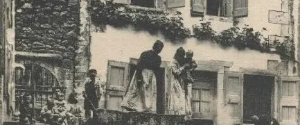 Carte postale ancienne représentant la fontaine d'eau chaude de Chaudes-Aigues, où les habitants utilisaient quotidiennement les eaux thermales au cœur du village.