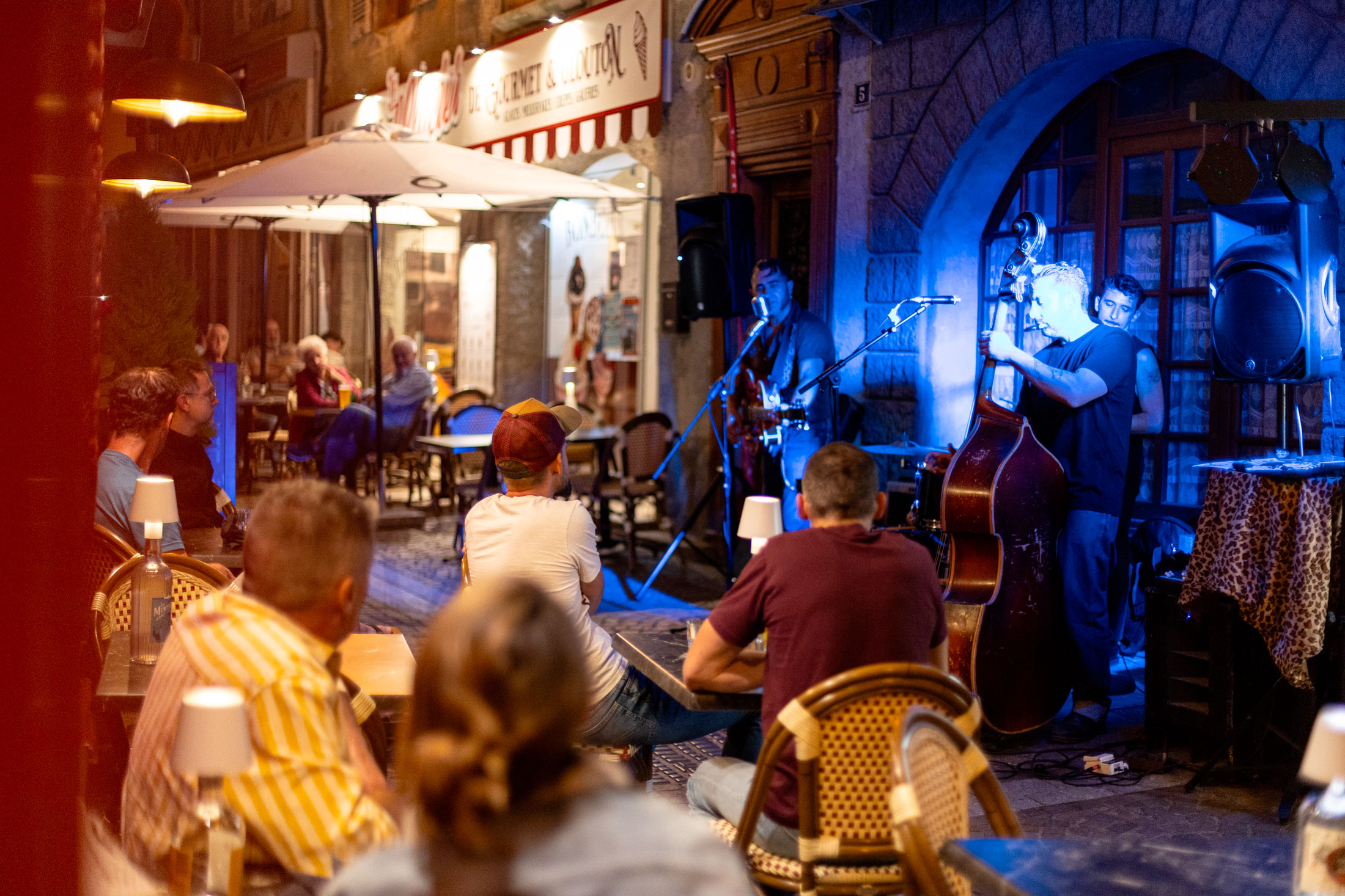 Concert des Terrasses Musicales à Chaudes-Aigues devant Gourmet & Glouton avec public en terrasse et musique live dans le centre-bourg